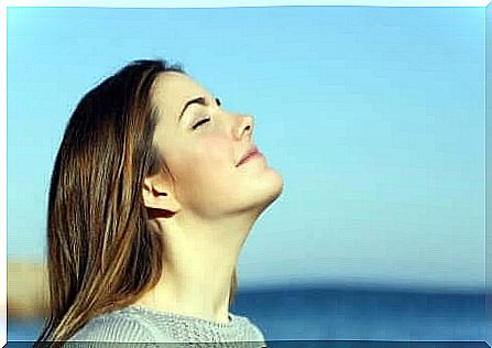 A woman standing with her face in the sun