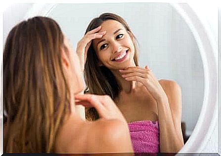 A woman doing skin care in front of the mirror.