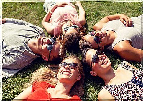 friends-lie-in-a-circle-on the% cc% 8a-grass