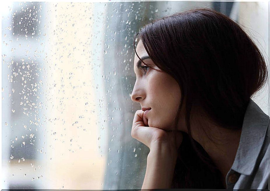 Woman with depression looking out the window