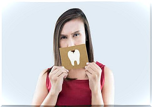 Woman holding a sign with a tooth with a caries in front of her mouth