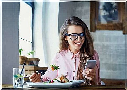 Woman eating while operating mobile phone