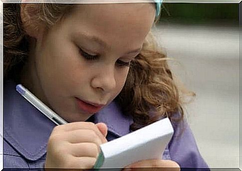 A girl practicing spelling in a notepad.